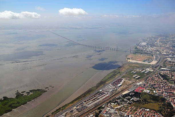Lisbon, Portugal: Vasco da Gama bridge from the Air - cable-stayed bridge crossing of the Tagus River at Mar da Palha, with Sacavém in the foreground, Lisbon on the right (Expo 98 / Parque das Nações) and Alcochete, Montijo, Samouco and Montijo airbase / airport on the top left - Tagus estuary from the air
