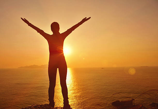 istock cheering woman sunrise seaside 490309483