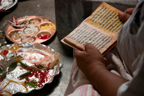 Hindu priest performing hindu rituals and reading the hindu scripts