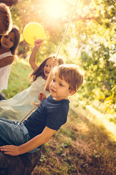 istock Group of kids in tire swing 490314759