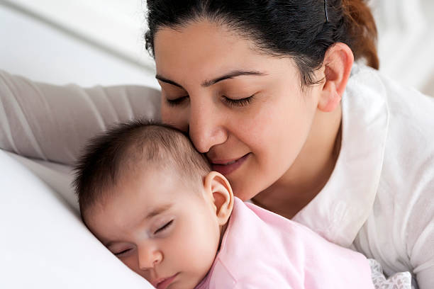 istock Mother Kissing Her Sleeping Newborn 490315931
