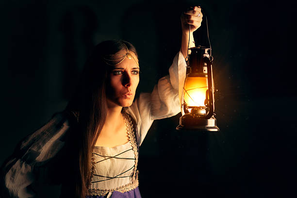 istock Curious Medieval Princess Holding Lantern Looking Outside 490336606
