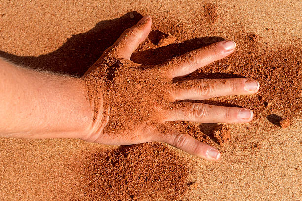 istock Red soil hand shape on sand like aboriginal art style 490338220