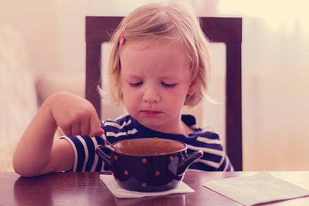 istock Little cute girl eats soup. 490339730