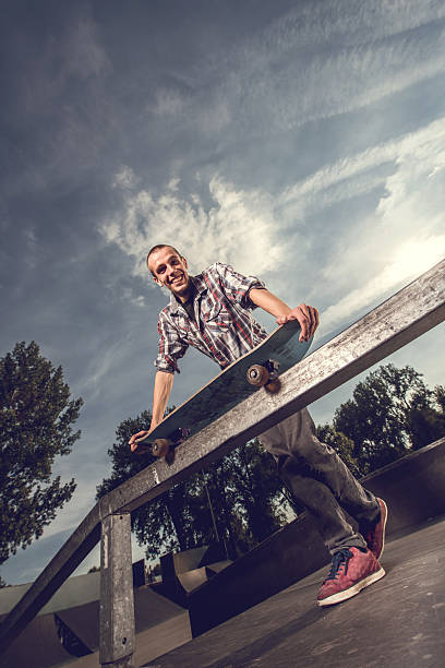 istock Below view of a happy skateboarder looking at the camera. 490342300