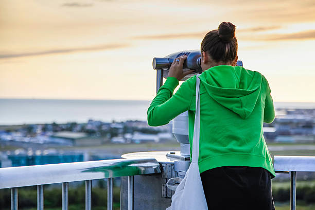 istock Young girl looking through a coin operated public binoculars 490342866
