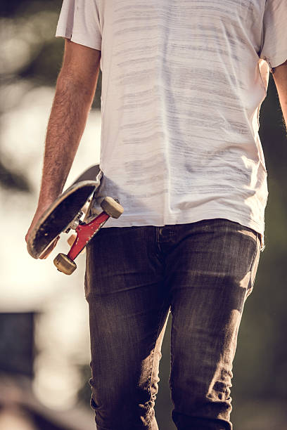 istock Unrecognizable man walking with a skateboard outdoors. 490343044