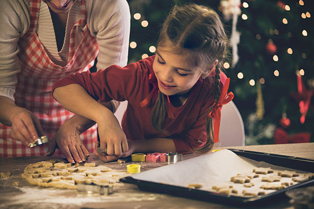mãe ajudando a filha com natal os'cookies' - pastry cutter family holiday child imagens e fotografias de stock