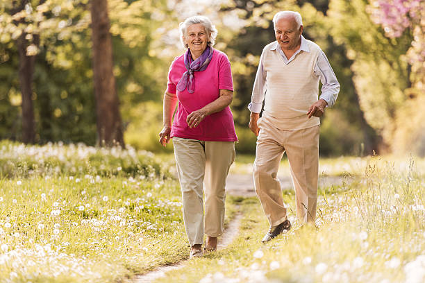 istock Happy elderly couple having fun while running in nature. 490345402