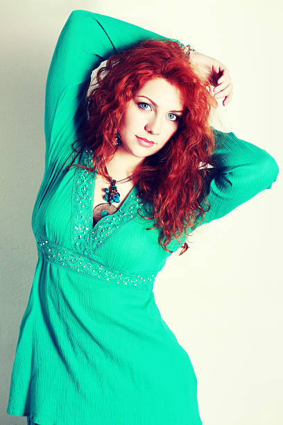 beautiful woman portrait of a beautiful woman with red curly hair. wearing a romantic green or turquoise dress Fashion retro toning. plus size boho clothing stock pictures, royalty-free photos & images
