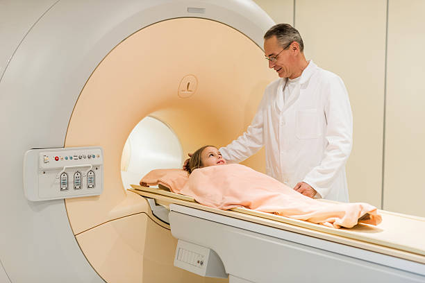 radiólogo sonriente hablando a niña antes de la mri. - mri scan radiologist cat scan cat scan machine fotografías e imágenes de stock