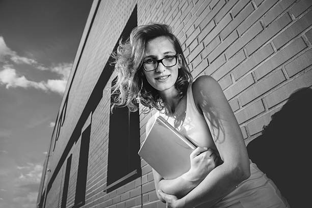 istock Beautiful student with laptop relaxing outside library 490360088
