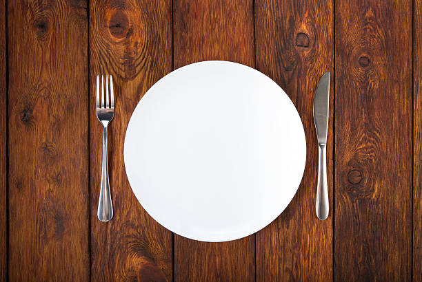 istock plate, knife and fork on wooden background 490362170