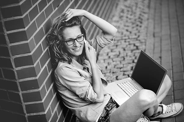 istock Beautiful student with laptop relaxing outside library 490364738