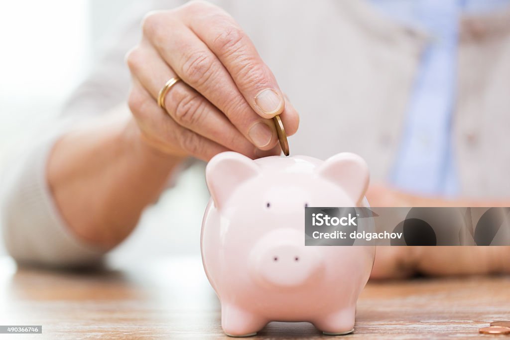 senior mujer manos poner dinero a alcancía - Foto de stock de Tercera edad libre de derechos