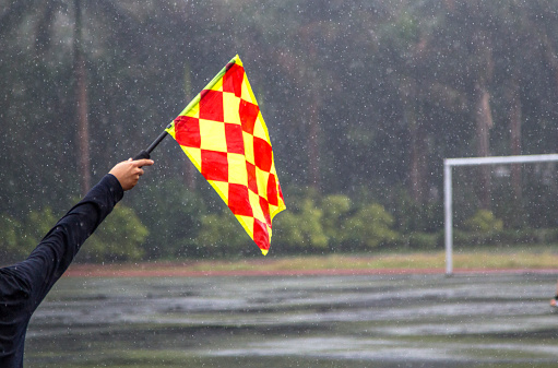 goal keeper holding corner flag, in the rain