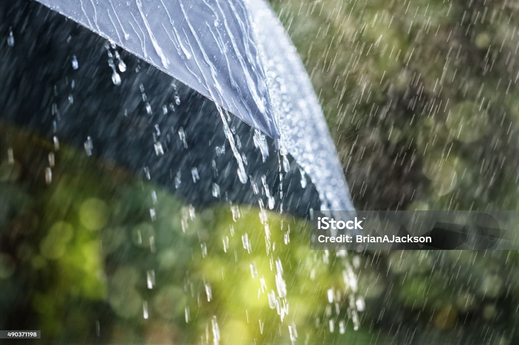 Rain on umbrella Rain drops falling from a black umbrella concept for bad weather, winter or protection Rain Stock Photo