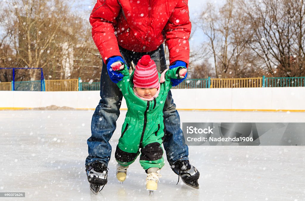 Padre e bambino imparare a skate in inverno - Foto stock royalty-free di 2015