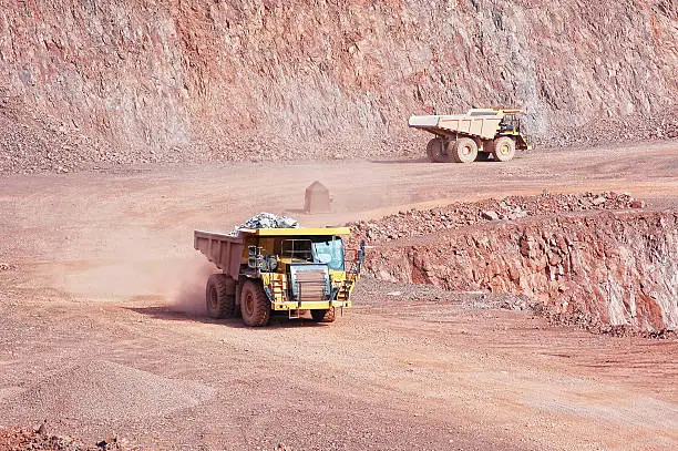 two dumper trucks in surface mine quarry. mining industry.