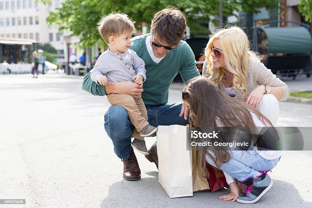 Family in shopping Young happy family looking in shopping bags at street.  Adult Stock Photo
