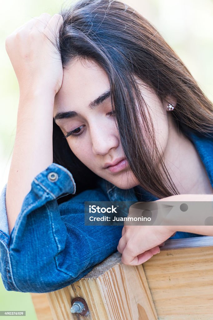 Sad girl Sad Young hispanic girl looking at the camera 16-17 Years Stock Photo