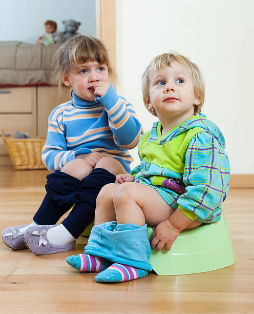 istock Two children  sitting on chamber pots 490376535