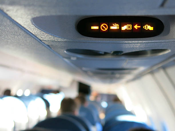 istock No Smoking Fasten Seatbelt Sign with Passengers on Airplane 490378223