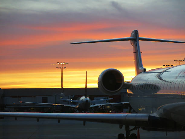 istock Peach Colored Sunset Sky,  Airport with Airplane Silhouette and Reflection 490381029