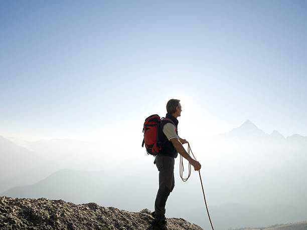 istock Climber stands holding rope on mountain summit 490388700