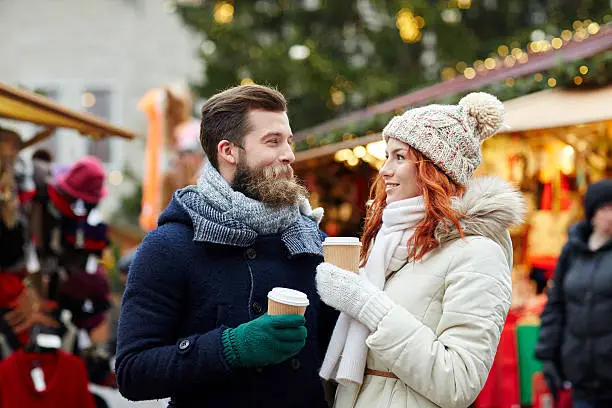 Photo of happy couple drinking coffee on old town street