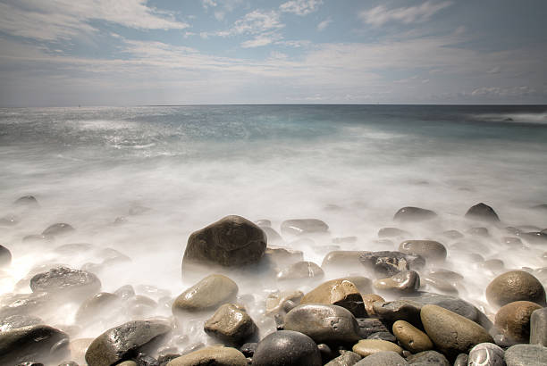 pietre e rocce sulla costa - long exposure rock cloud sky foto e immagini stock