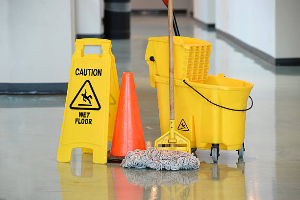 Wet Floor Sign With Mop Caution sign with mop and bucket on office floor mop photos stock pictures, royalty-free photos & images