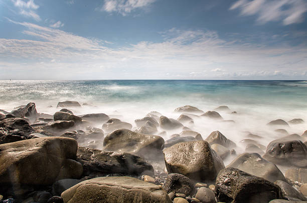 pietre e rocce sulla costa - long exposure rock cloud sky foto e immagini stock