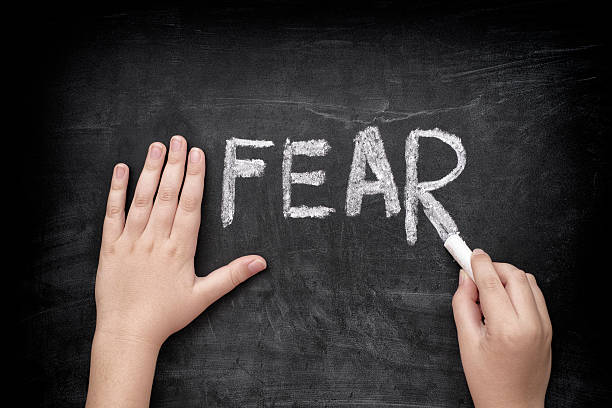istock Child writing word Fear on blackboard 490391874
