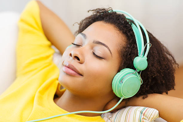 mujer feliz con auriculares escuchando la música - women sofa teenage girls hairstyle fotografías e imágenes de stock