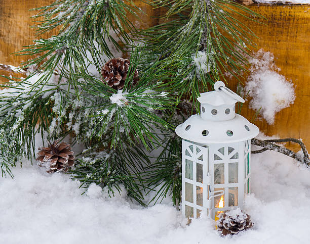 istock Decorative lantern burning in the snow with a conifer branch 490394624