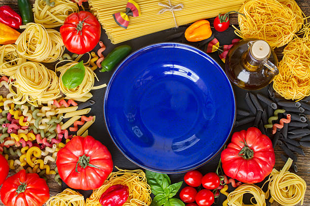 istock Raw pasta with ingridients and blue plate 490396378