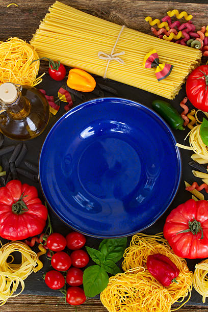istock Raw pasta with ingridients and blue plate 490396498