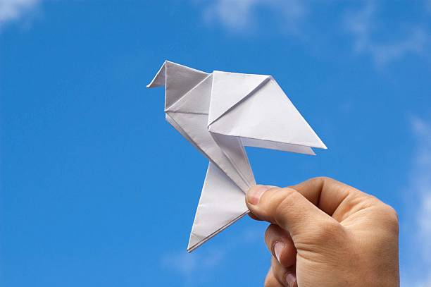 istock Paper origami dove against blue sky 490397362