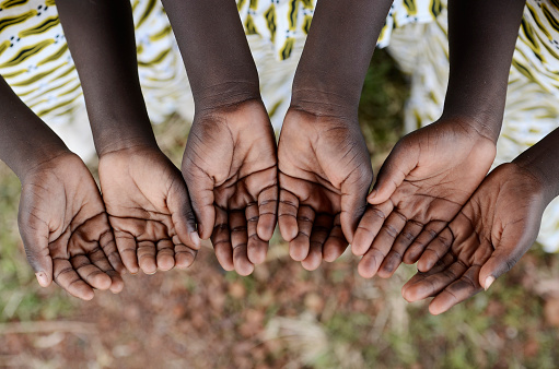African black children hold their hands cupped to beg for help, health, education and peace for their continent.