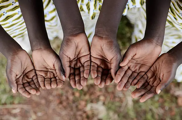 African black children hold their hands cupped to beg for help, health, education and peace for their continent.