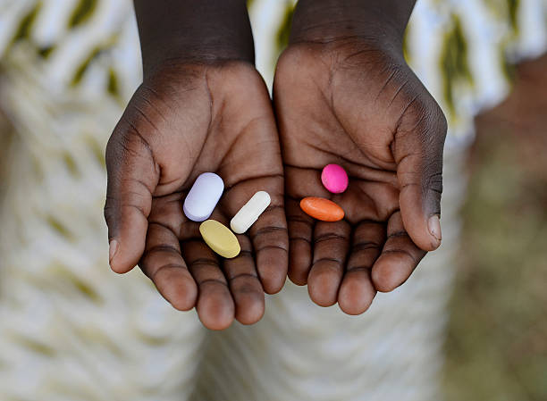 Healthy Lifestyle Medicine African Black Boy Holding Colorful Pills Background stock photo