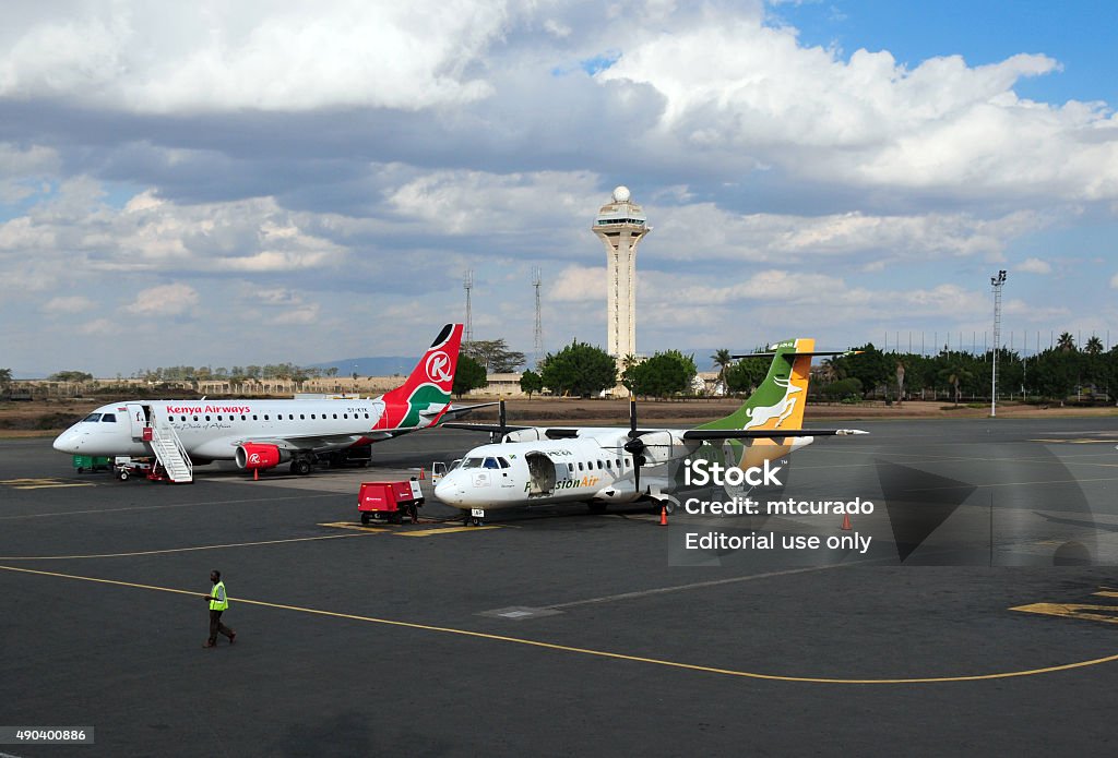 Airliners at Jomo Kenyatta International Airport, Nairobi, Kenya Nairobi, Kenya - August 24, 2008: Kenya Airways Embraer 170 and Precision Air ATR 42-320 being serviced at Jomo Kenyatta International Airport  2015 Stock Photo