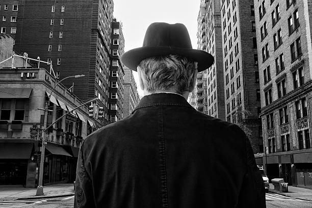 Man with hat from rear view in business district in Manhattan,NYC. black and white.