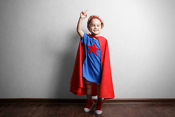 istock Happy child in superhero suit against gray wall. 490430360