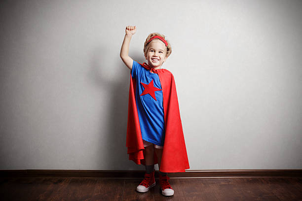 istock Happy child in superhero suit against gray wall. 490430422