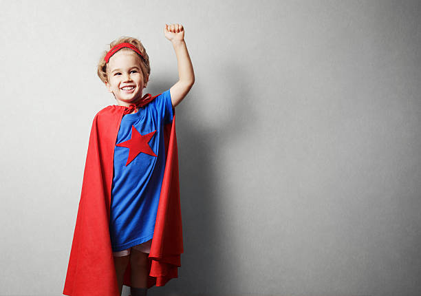 istock Happy child in superhero suit against gray wall. 490430462