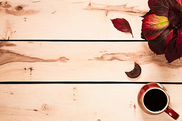 istock Autumn background. Cup of coffee on the table with leaves 490431436