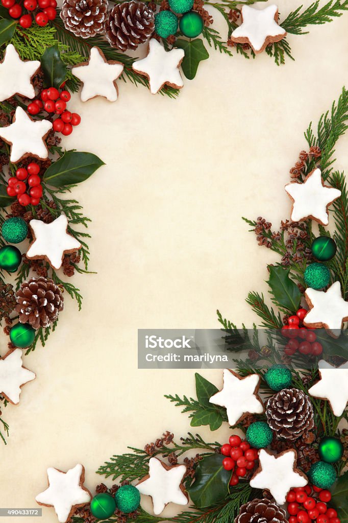 Gingerbread Abstract Border Christmas gingerbread star biscuit abstract background border with green bauble decorations, holly and winter greenery over old parchment paper. 2015 Stock Photo