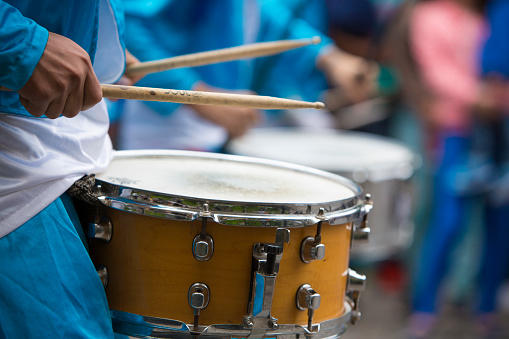 Salta, Argentina - December 18, 2014: Close up on hands from performer drumming and celebrating the opening of the carnival of Salta in the street with colorful costumes. North of Argentina 2014